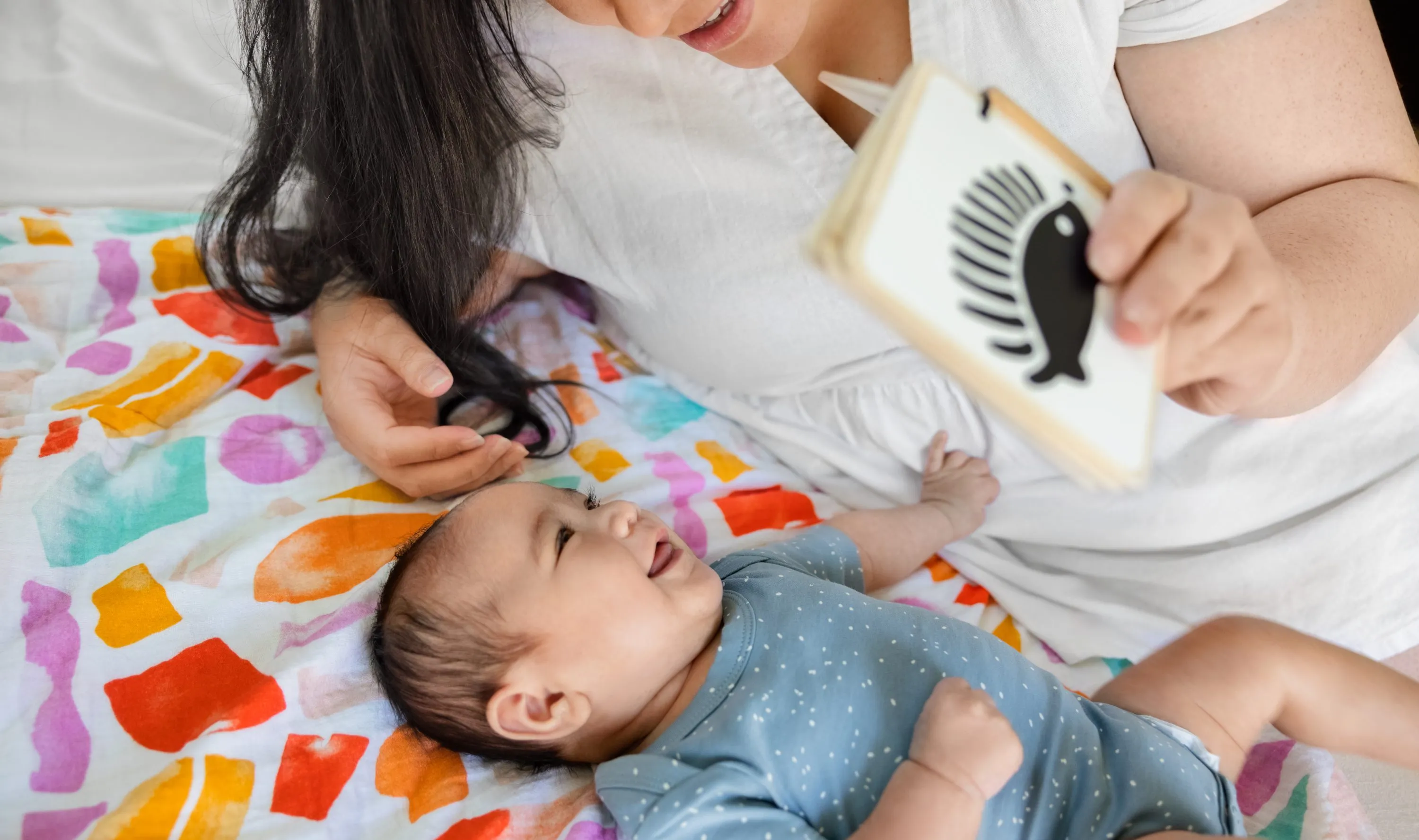 Baby and mother looking at the Wooden Book from The Looker Play Kit